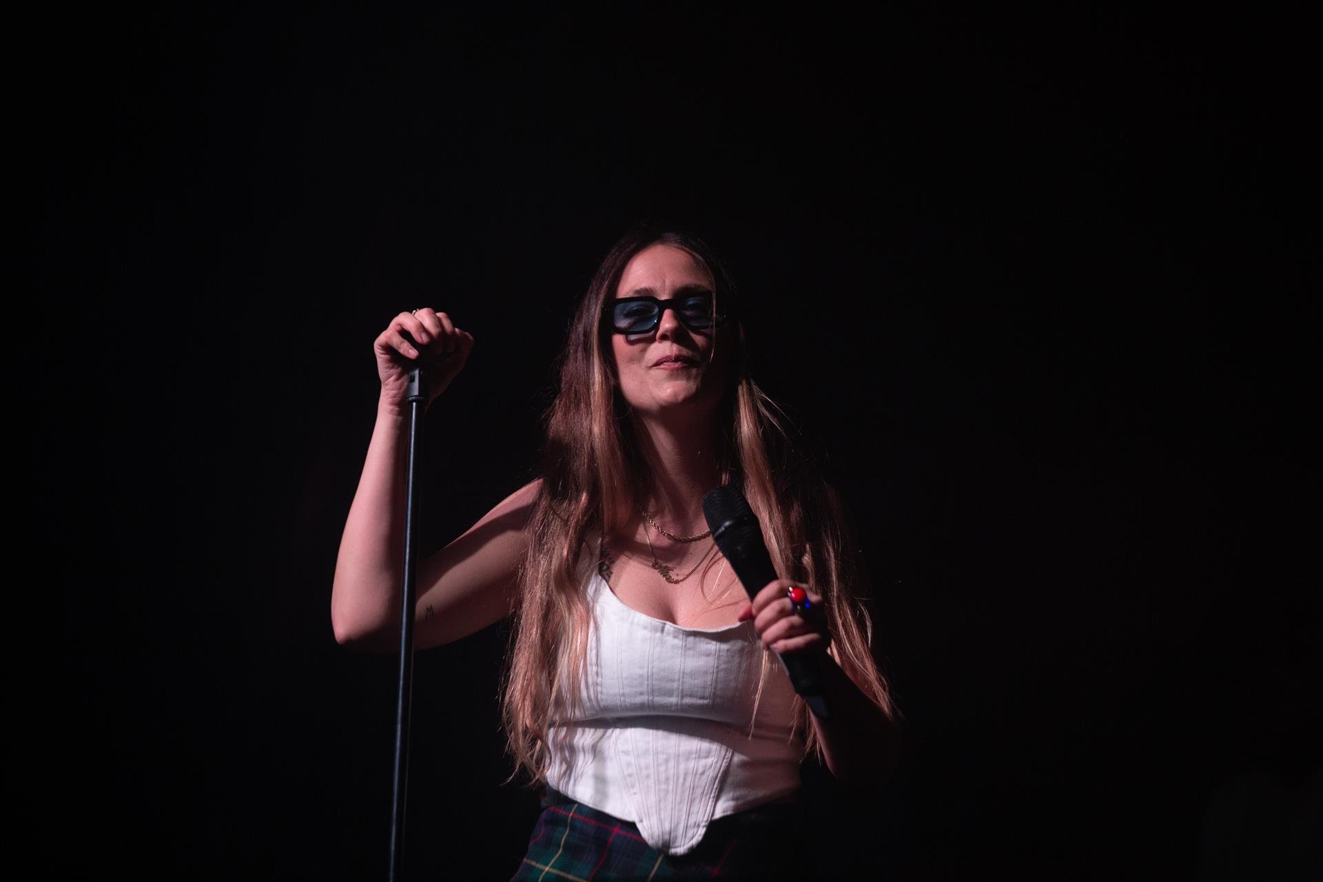 Mujer con un micrófono y gafas de sol