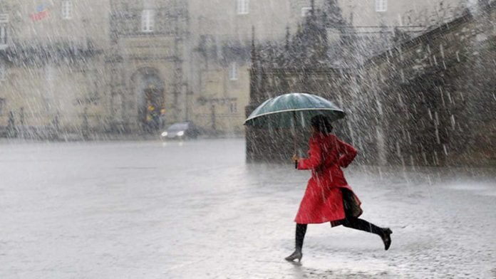 Una mujer corre para resguardarse de la lluvia
