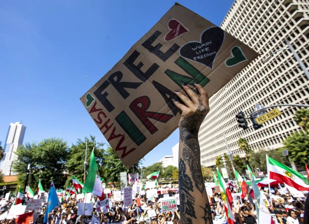 Mujer sosteniendo una pancarta en la que se lee "Free Iran"