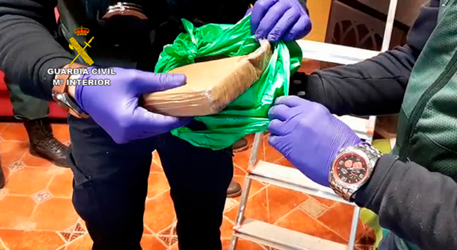 Dos agentes de la Guardia Civil sosteniendo un paquete de cocaína.