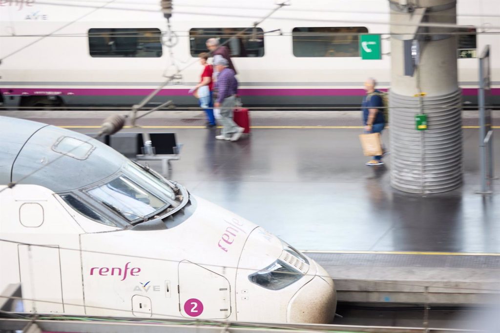 Viajeros junto a un tren de alta velocidad