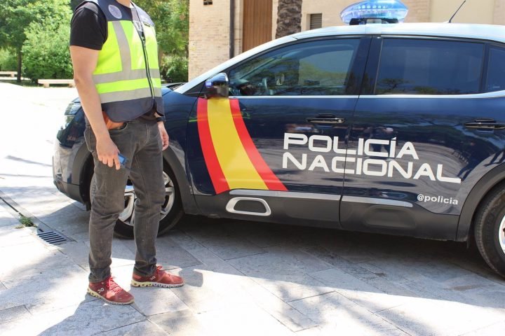 Un agente y vehículo de la Policía Nacional de España