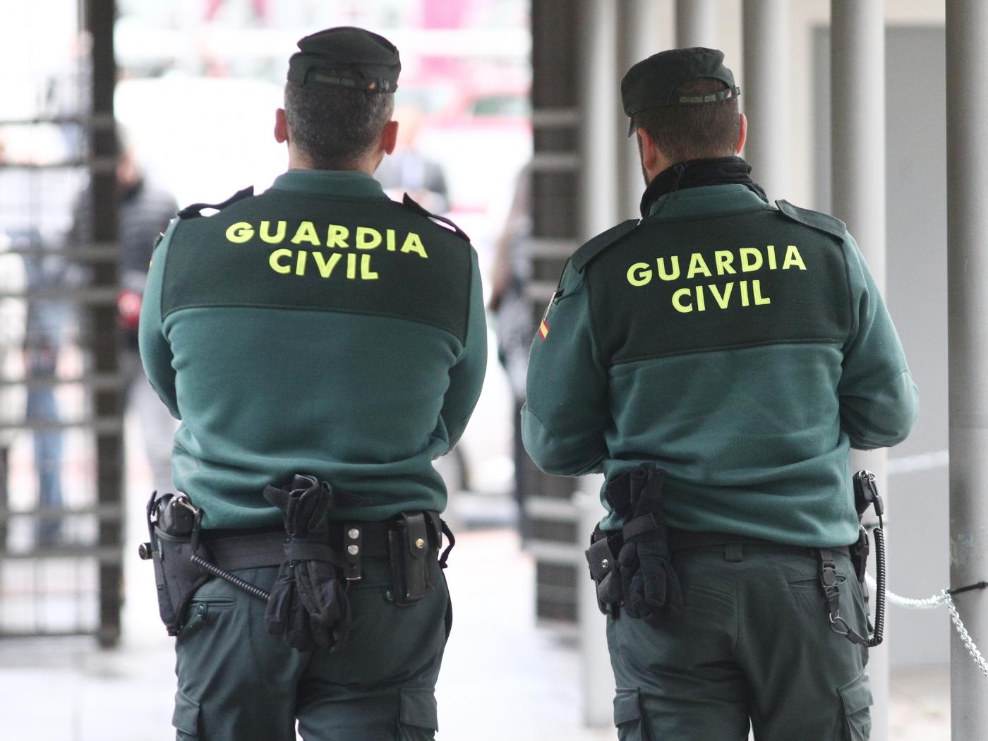 Dos agentes de la Guardia Civil de espalda. | Fuente: Europa Press