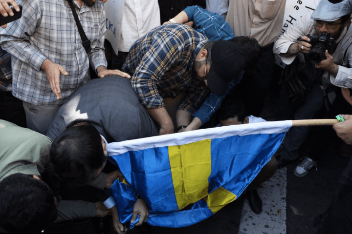 Un grupo de manifestantes quema una bandera sueca en Teherán