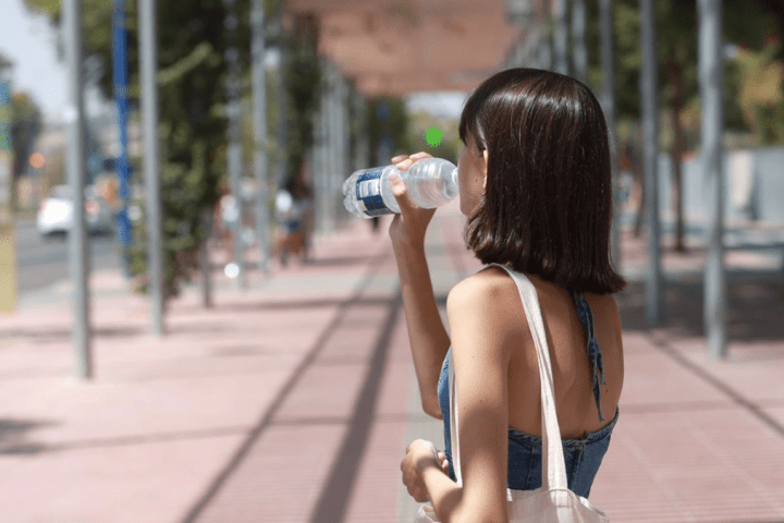 Una joven bebe agua para refrescarse ante las altas temperaturas