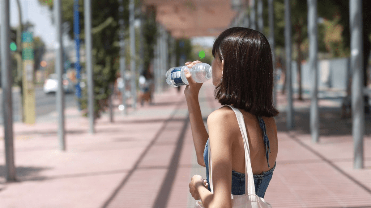 Una joven bebe agua para refrescarse ante las altas temperaturas