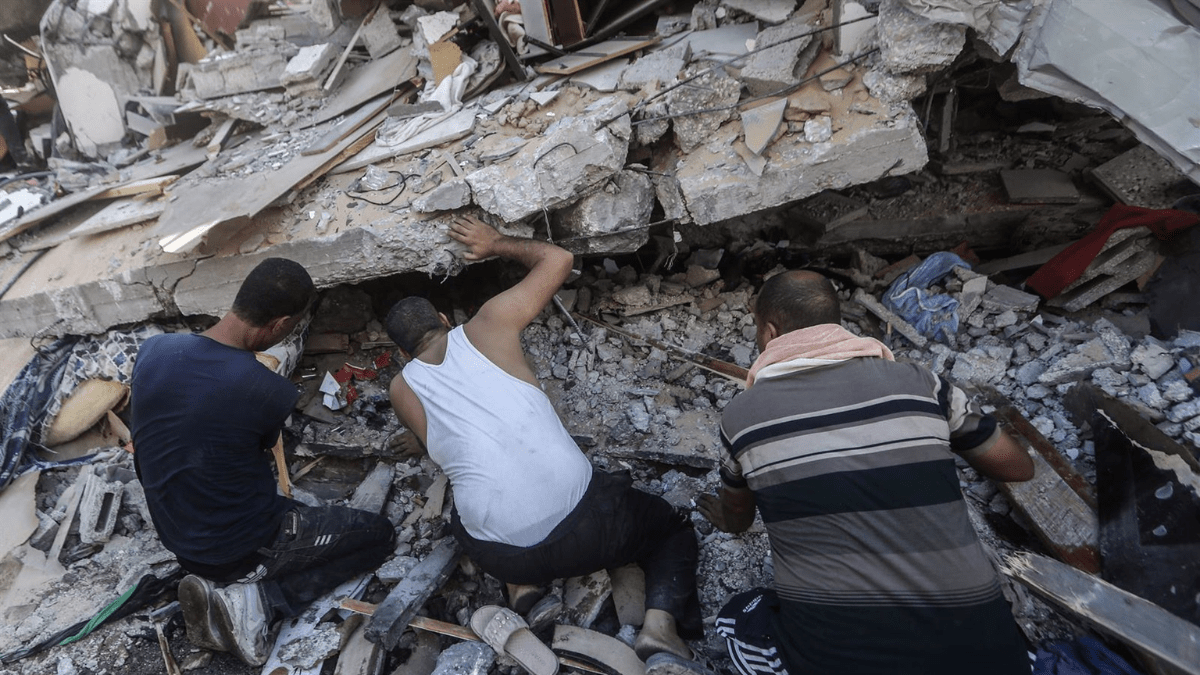Palestinos buscando víctimas entre los escombros de un edificio en la Franja de Gaza