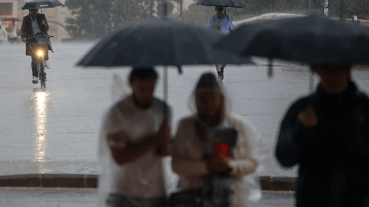 Varias personas se resguardan bajo un paraguas de la lluvia, el viento y el mal tiempo | Fuente: Róber Solsona / Europa Press aemet mal día para