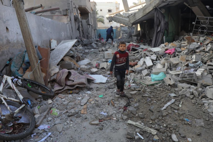 Un niño palestino camina sobre los escombros de Gaza