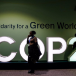 Una clmático desarrollo mujer pasa junto al logo de la COP29 en el Estadio Olímpico de Bakú. Foto: Dominika Zarzycka / DPA