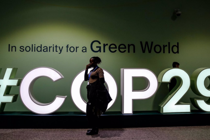 Una clmático desarrollo mujer pasa junto al logo de la COP29 en el Estadio Olímpico de Bakú. Foto: Dominika Zarzycka / DPA