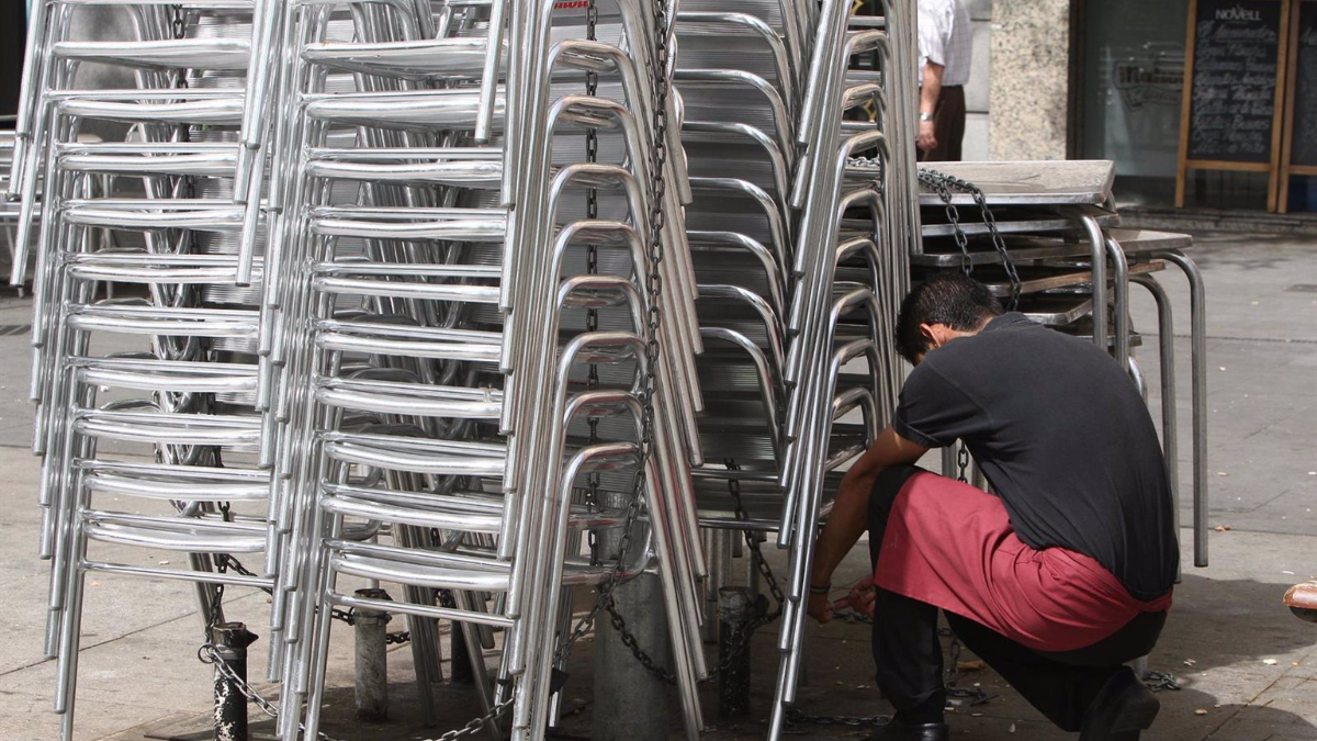 Un trabajador recoge la terraza de un local hostelero