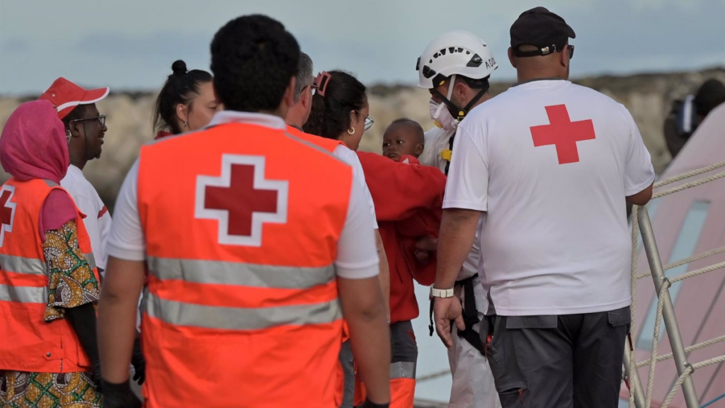 Trabajadores de la Cruz Roja atienden a los 190 migrantes rescatados por una embarcación de Salvamento Marítimo tras llegar anoche en una patera