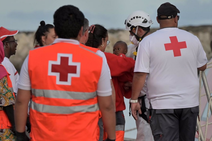 Trabajadores de la Cruz Roja atienden a los 190 migrantes rescatados por una embarcación de Salvamento Marítimo tras llegar anoche en una patera