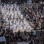 Decenas de personas llevan carteles con nombres de mujeres asesinadas por violencia machista durante una manifestación por el 25N